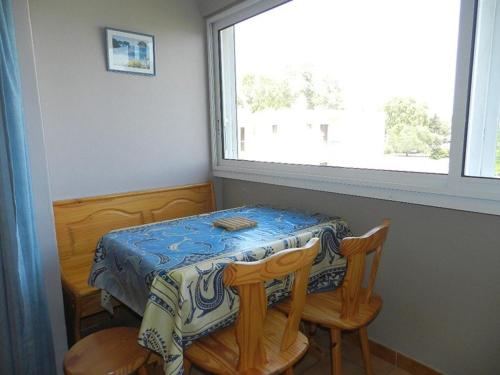 une table et deux chaises dans une pièce avec une fenêtre dans l'établissement Studio 3 Couchages à 2 min de la Plage - Bormes-les-Mimosas, Parking Inclus - FR-1-251-720, à Bormes-les-Mimosas