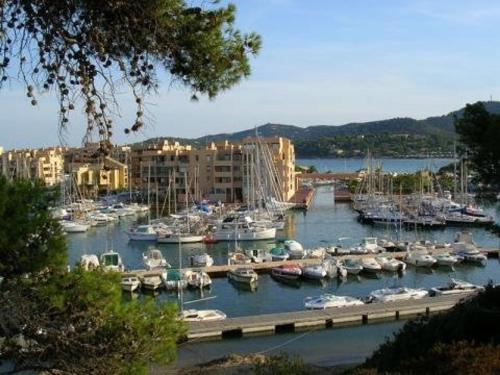 un port de plaisance avec des bateaux dans l'eau et des bâtiments dans l'établissement Appartement 4 couchages à 350m de la plage avec garage privatif à Bormes-les-Mimosas - FR-1-251-725, à Bormes-les-Mimosas