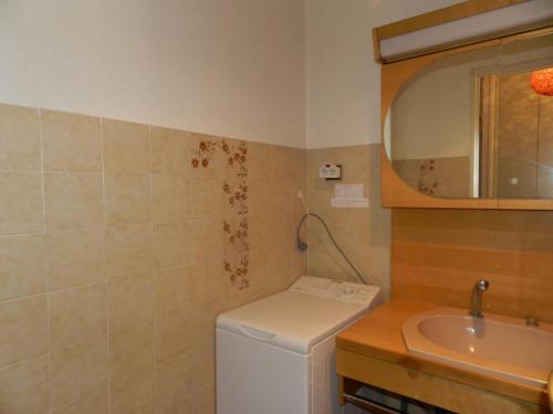 une salle de bain avec un lavabo et une machine à laver dans l'établissement Charmant T2 avec grande terrasse à 250m de la plage - 4 couchages, garage privé, ménage inclus - FR-1-251-741, à Bormes-les-Mimosas