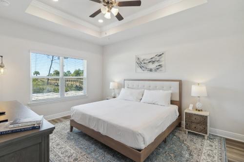 Saint Joe BeachにあるWindmark - Jasmine by the Beachのベッドと天井扇風機のある寝室