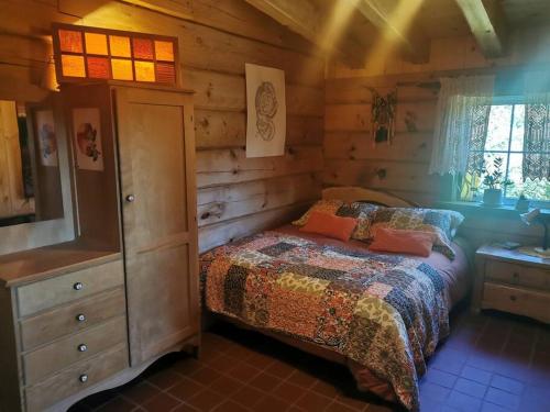 1 dormitorio con 1 cama en una cabaña de madera en Gîte de l'herboriste, en Sainte-Rose-du-Nord