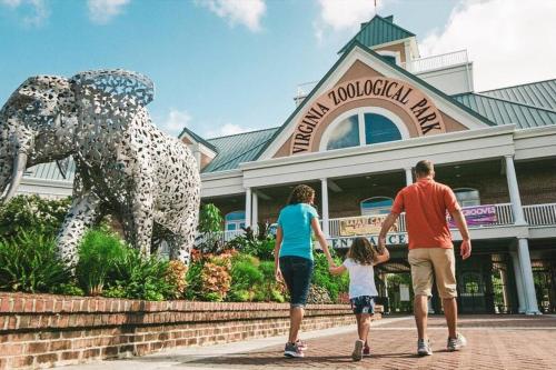 a family walking in front of a mall with an elephant statue at Home Near Downtown Norfolk in Norfolk