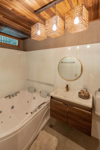 a bathroom with a large tub and a mirror at Hotel Isabella Tayrona in Los Naranjos
