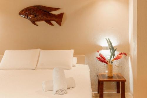 a bedroom with a bed with a fish on the wall at Hotel Isabella Tayrona in Los Naranjos