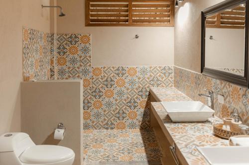 a bathroom with a white toilet and a sink at Hotel Isabella Tayrona in Los Naranjos