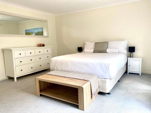 Un dormitorio con una cama y una cómoda. en Melville Views Apartment, en Albany