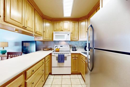 a kitchen with wooden cabinets and a refrigerator at Lichenhearth # 4 in Snowmass Village