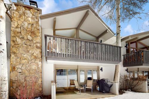 a house with a balcony and a stone wall at Lichenhearth # 4 in Snowmass Village