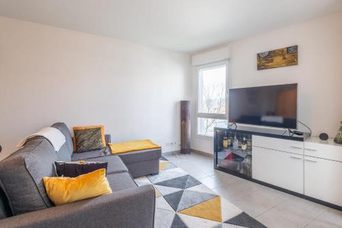 un salon avec un canapé et une télévision à écran plat dans l'établissement Joli T2 de 57 m proche lac et Vieille Ville, à Annecy