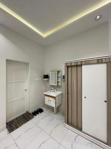uma casa de banho branca com um lavatório e um espelho em استراحة عمر em Hail