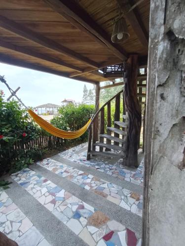 a walkway with a hammock on a patio at Hotel Palma Coco in Ayampe