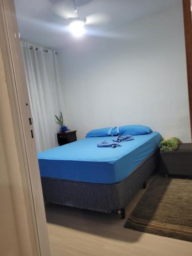 a bedroom with a bed with blue pillows at AP prox CT Galo, Aquabeat, Aeroporto, Cidade Administrativa in Vespasiano