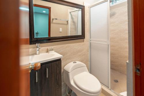 a bathroom with a toilet and a sink and a mirror at Hotel Isabella Tayrona in Los Naranjos