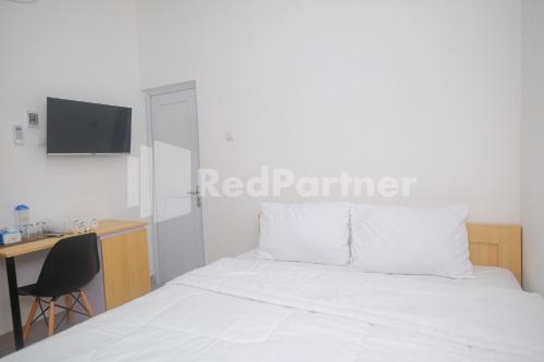 Кровать или кровати в номере River House Mitra RedDoorz