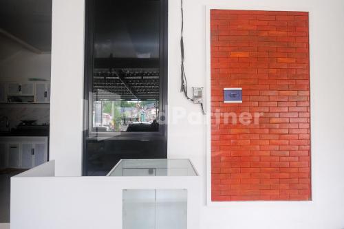 a red brick wall next to a counter in a kitchen at River House Mitra RedDoorz in Jatingaleh