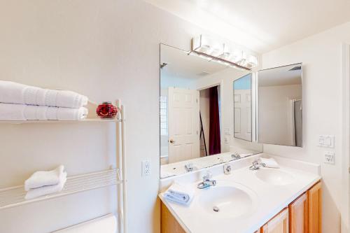 Baño blanco con lavabo y espejo en Endless Canyon Escape, en Tucson