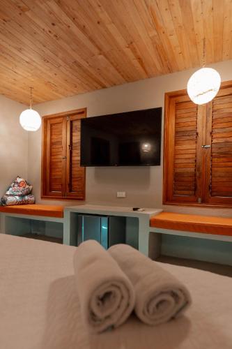 a room with a bed with a television and towels at Hotel Isabella Tayrona in Los Naranjos