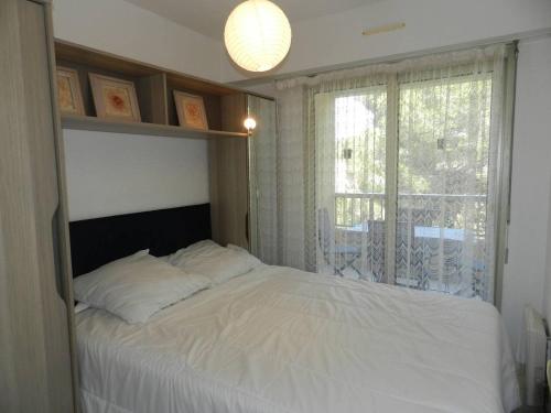 une chambre avec un lit blanc et une fenêtre dans l'établissement Appartement Moderne avec Terrasse, Parking et Proximité Plage à Bormes les Mimosas - FR-1-251-745, à Bormes-les-Mimosas