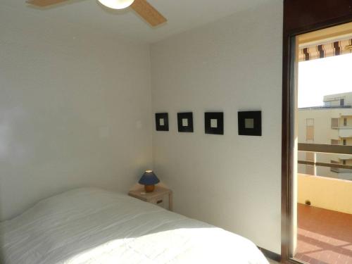 une chambre blanche avec un lit et une fenêtre dans l'établissement Appartement 2 pièces avec terrasse et parking à 150m de la plage - FR-1-251-767, à Bormes-les-Mimosas