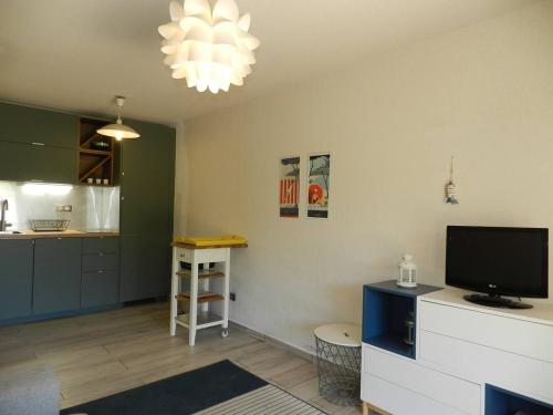 un salon avec une télévision et une cuisine dans l'établissement Appartement 2 pièces avec Jardin, à 250m de la Plage - Bormes-les-Mimosas - FR-1-251-768, à Bormes-les-Mimosas