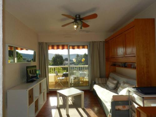 une chambre avec un lit et un ventilateur de plafond dans l'établissement Appartement cosy avec terrasse, proche plage et commerces - Bormes-les-Mimosas - FR-1-251-785, à Bormes-les-Mimosas