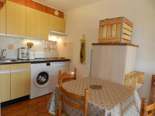 une cuisine avec une table et une machine à laver dans l'établissement Appartement T2 cosy avec jardin, proche plage et commerces – Bormes-les-Mimosas - FR-1-251-756, à Bormes-les-Mimosas