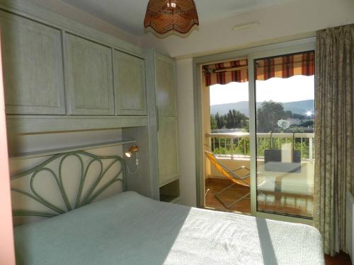 Schlafzimmer mit einem Bett und Blick auf einen Balkon in der Unterkunft Appartement Bormes-les-Mimosas, 2 pièces, 4 personnes - FR-1-251-785 in Bormes-les-Mimosas