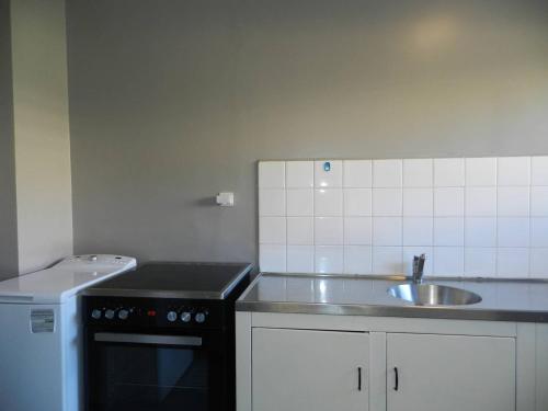 une petite cuisine avec un évier et une cuisinière dans l'établissement Appartement climatisé, terrasse, parking privé, à 150m de la plage - Bormes-les-Mimosas - FR-1-251-759, à Bormes-les-Mimosas
