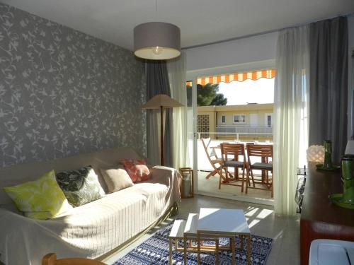un salon avec un canapé et une table dans l'établissement Appartement climatisé, terrasse, parking privé, à 150m de la plage - Bormes-les-Mimosas - FR-1-251-759, à Bormes-les-Mimosas