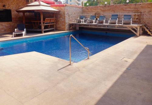 a swimming pool with chairs and an umbrella at Dania in Pattaya
