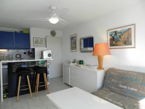 une cuisine et un salon avec une table et un canapé dans l'établissement Appartement T2 avec coin nuit, piscine, parking sécurisé, proche plage - Le Lavandou - FR-1-251-743, au Lavandou