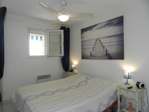 une chambre avec un lit et un tableau au mur dans l'établissement Appartement T2 avec coin nuit, piscine, parking sécurisé, proche plage - Le Lavandou - FR-1-251-743, au Lavandou