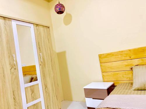 1 dormitorio con 1 cama con cabecero de madera en Endhaa, Divers Home en Fuvahmulah
