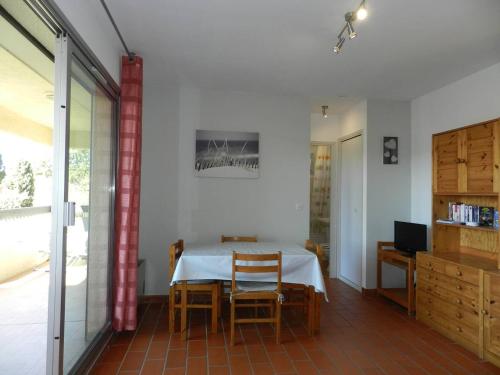 une salle à manger avec une table et des chaises blanches dans l'établissement Charmant T2 avec terrasse et parking au calme, Le Lavandou - FR-1-251-766, au Lavandou