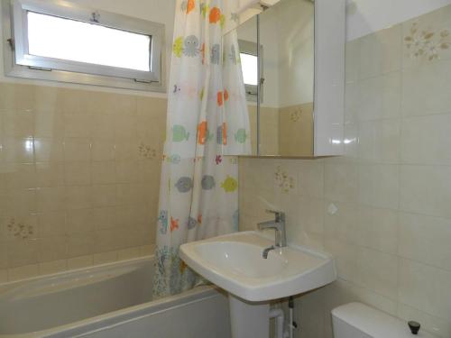 une salle de bain avec un lavabo et un rideau de douche dans l'établissement Charmant T2 avec terrasse et parking au calme, Le Lavandou - FR-1-251-766, au Lavandou