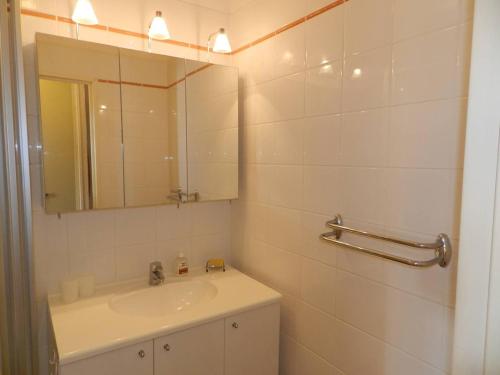 une salle de bain blanche avec un lavabo et un miroir dans l'établissement Charmant appart T2 avec terrasse, proche plage et commerces, garage privé, Bormes-les-Mimosas - FR-1-251-755, à Bormes-les-Mimosas