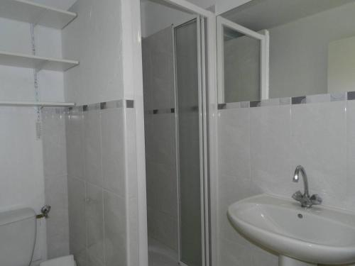 une salle de bain blanche avec une douche et un lavabo dans l'établissement Appartement T2 avec Cabine, Piscine, Parking Privé - Proche Plage et Commerces, Le Lavandou - FR-1-251-774, au Lavandou