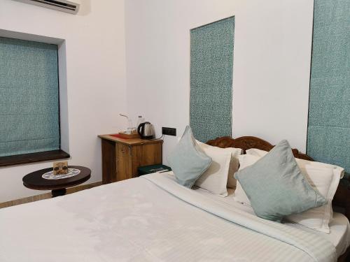 a bedroom with a bed with white sheets and pillows at Ananda Holiday Home in Ambalavayal