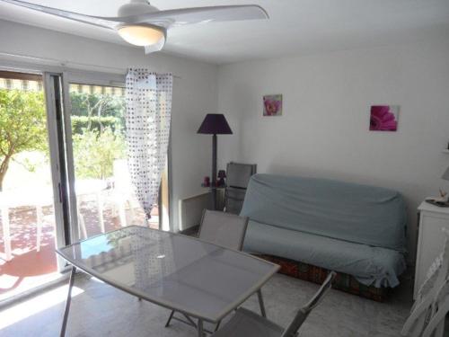 - un salon avec une table en verre et un lit dans l'établissement Appartement T2 avec jardin, terrasse et parking - 4 couchages, Le Lavandou - FR-1-251-790, au Lavandou