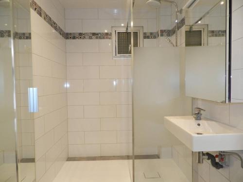 une salle de bain blanche avec un lavabo et une douche dans l'établissement Appartement T2 avec jardin, terrasse et parking - 4 couchages, Le Lavandou - FR-1-251-790, au Lavandou