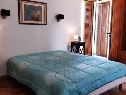 sypialnia z łóżkiem z niebieską kołdrą w obiekcie Maison Bormes-les-Mimosas, 4 pièces, 8 personnes - FR-1-251-777 w mieście Bormes-les-Mimosas