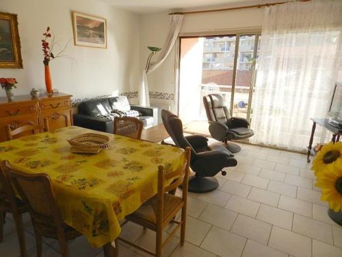 un salon avec une table et des chaises et une fenêtre dans l'établissement Appartement T2 avec Terrasse Sud, Garage, Centre-ville du Lavandou, Proche Plage - FR-1-251-789, au Lavandou