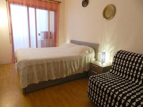 une chambre avec un lit, une chaise et une fenêtre dans l'établissement Appartement T2 avec Terrasse Sud, Garage, Centre-ville du Lavandou, Proche Plage - FR-1-251-789, au Lavandou