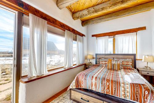 a bedroom with a bed and windows at Sunset Studio in Taos