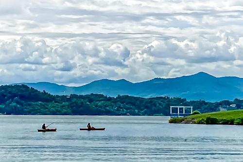 two people in boats on a lake with mountains in the background at Smoky Mountain Lake Retreat in Dandridge