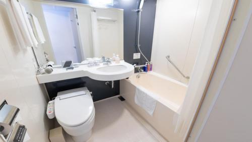 La salle de bains est pourvue de toilettes, d'un lavabo et d'une baignoire. dans l'établissement Richmond Hotel Kagoshima Tenmonkan, à Kagoshima