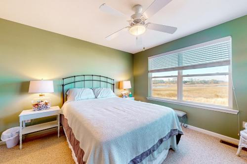 a bedroom with a bed with a ceiling fan and a window at Bethany Bay --- 30224 Driftwood Court Unit #7504 in Ocean View