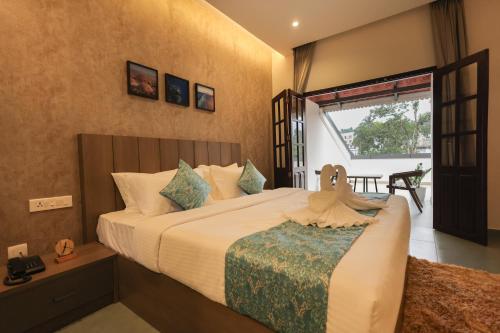 een slaapkamer met een groot bed en een raam bij Holidays Garden by Bestinn Leisure Wayanad in Kalpatta