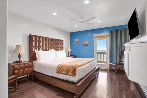 a bedroom with a large bed with a blue wall at The Marvelous 24 in Flagler Beach