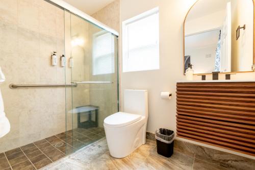 a bathroom with a toilet and a glass shower at SōLE Luxury Condo's in Cocoa Beach